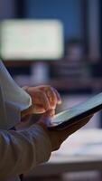 Close up of woman employee texting, sending and reading messages during break standing in business office late at night. Businesswoman using modern technology network wireless overworking in midnight photo