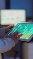 Close-up photo of woman hands holding tablet computer analysing graphs standing in start-up office late at night. Business woman using social network, texting and blogging working overtime for job