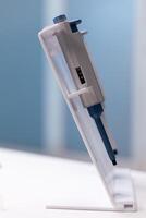 Close up of professional micro pipette on lab desk. Tool of chemical equipment in science laboratory used for research and mixing liquid, substance. Instrument for scientific test photo