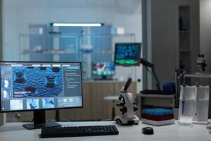 Computer with microbiology virus expertise on display standing on table during biochemistry experiment in biological hospital laboratory. Healthcare treatment development photo