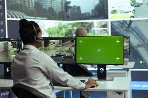 Indian employee gather intelligence on urban traffic activity next to isolated mockup screen, working in monitoring room with CCTV street surveillance footage. Real time radar . photo