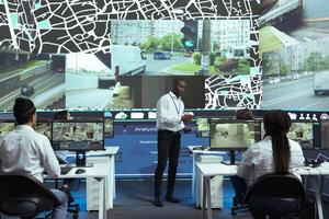 African american manager overseeing monitoring activity in control center, shipping agency ensuring express shipment on all orders. Employees operators guiding couriers in traffic. photo