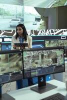 Indian female manager gathers intelligence on cargo delivery logistics by communicating alternative routes through traffic via satellite navigation. Leader works with her team in control center. photo