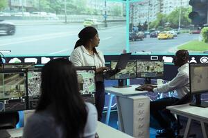 Diverse employees monitoring urban traffic in control center agency, following cars and their license plate data through surveillance and CCTV networks. Government radar sensors. photo