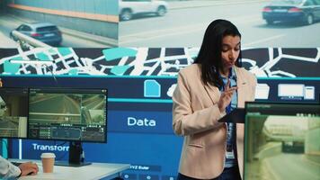 Indian manager and her team monitoring their delivery cars in traffic, following the best routes through surveillance CCTV system to guide the couriers. Control center map navigation. Camera A. photo