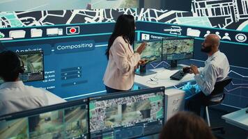 Indian manager and her team monitoring their delivery cars in traffic, following the best routes through surveillance CCTV system to guide the couriers. Control center map navigation. Camera B. photo