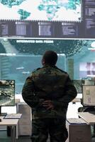 Woman army conscript examines big screen with surveillance imagery in power base monitoring room, analyzing important live transmission to set mission objectives and resources. GPS tracking. photo