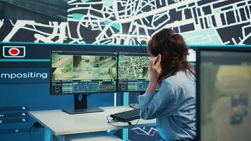Woman call center operator guiding delivery truck drivers on different routes to avoid traffic and help with express shipment. Agency uses surveillance CCTV and gps tracking. Camera B. photo
