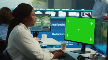 African american operator works with isolated display and satellite map, guiding the delivery truck driver to arrive at shipment location pin. Employee helps with heavy traffic on CCTV. Camera A. photo