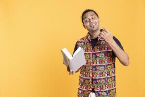 Indian man reading book aloud, narrating story for audience. Person enjoying literature novel, reciting from pages, entertaining spectators, isolated over studio background photo