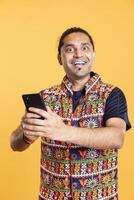 Portrait of overjoyed person using smartphone, having positive surprise facial expression after seeing picture on social media feed. Astonished man holding mobile phone, relaxing, feeling ecstatic photo
