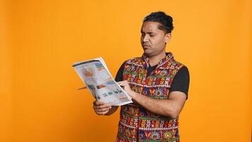 Irked manager browsing though financial audit report files, disappointed by work done by employees, studio background. Upset team leader throwing wrongly done paperwork in frustration, camera B photo