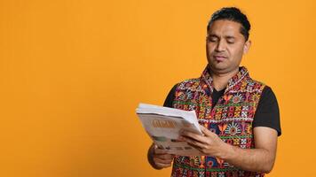 Irked manager looking over company financial profit report audit, disappointed by results, isolated over studio background. Mad indian man throwing business documents in frustration, camera A photo