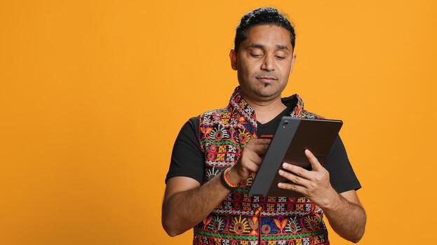 Man upset after lacking necessary money while trying to buy stuff online on tablet. Sad person looking at debit card after getting transaction rejected on device, studio background, camera A photo