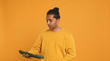 Delivery man doing face palm, shocked to see he displaced order in thermal backpack, throwing vegetables. Courier making mistake, packing incorrect groceries in bag, studio background, camera A photo