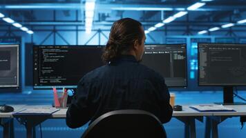 Engineer drinking coffee and programming in server room with equipment storing datasets. Employee enjoying caffeine beverage, typing code on PC to mend data center racks doing computational operations photo