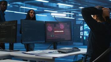 Programmer in server hub workspace requesting assistance from colleagues during hacking attack on computers. Software developer asking for help from colleagues to protect data from unauthorized access photo