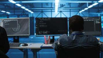 Person with disability next to multiracial coworkers in data center coding on computer. Wheelchair user and multiethnic team working together, doing programming, overseeing server clusters photo