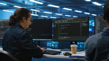 Engineers coding together in high tech server hub, using computers to analyze data, ensuring seamless data flow. Colleagues examining infrastructure in data center, ensuring system integrity and security photo