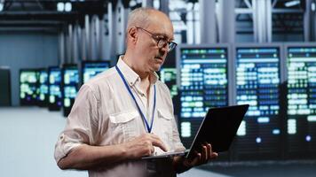 Focused IT support executive in data storage company equipped to handle complex computational operations, doing checking on server devices, verifying efficiency parameters to prevent liabilities photo