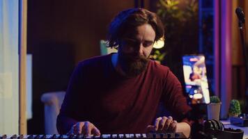 Artist teaching online piano lessons from his home studio, recording tutorial and playing midi controller synthesizer. Instructor explaining electronic keyboard notes, music industry. Camera A. photo
