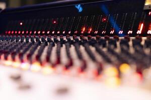 Pre amp knobs and buttons on mixing console panel board control desk, audio technical gear used in music post production. Modern tools and equipment in professional studio. Close up. photo