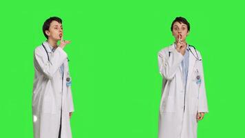 General practitioner showing hush symbol to be quiet and keep secrecy, putting finger over lips for privacy and silence expression. Medic doing mute symbol, asking to be quiet. Camera B. photo