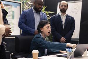 Displeased angry supervisor analyzing team progress and efficiency, crazy manager screaming at her staff members and being irritated with their workflow. Disappointed business woman. photo