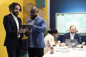 General director and CEO sharing insight about a new expansion strategy with their employees, presenting data reports an infographics to analyze business activity status. Coworkers in a meeting. photo