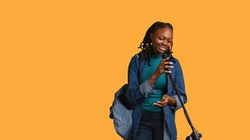 African american motivational speaker talking in microphone, addressing audience, holding speech, studio background. Inspiring woman using mic to present life lectures, camera B photo