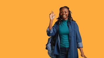 Enthusiastic african american student raising hand up to answer question, excited to tell teacher explanation to question in class, isolated over studio background, camera B photo