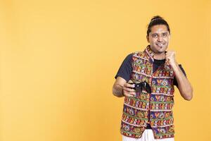 Happy gamer celebrating after winning game on gaming console, studio background. Delighted man bragging after being victorious in videogame, defeating all enemies using gamepad photo