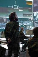 Signal support system specialists providing guidance and crucial battlefield data to the recruits in the field. Military defense program division in power base monitoring room. photo