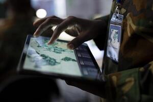 Army operations IT professional monitors satellite world map to search for enemy vessels or submarines, ensuring national safety within the territory. Operates on surveillance imagery. Close up. photo