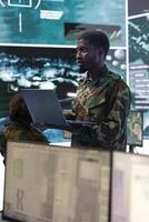 Intelligence analyst technician coordinating air support to provide assistance for ground troops, ensures correct functioning for future warfare operations. Works in reconnaissance control room. photo