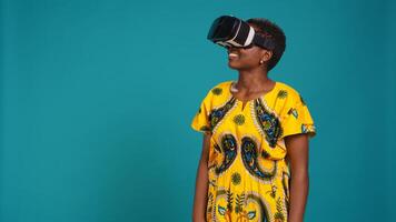 Young happy woman working with a virtual reality headset in studio, using the innovative 3d simulation experience with modern equipment. VR glasses on girl in traditional ethnic clothes. Camera B. photo