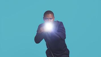 Portrait of security staff member tasked with evicting trespassers turns on flashlight. Patrolling agent maintains secure environment with lantern device, spotting people, studio background, camera B photo