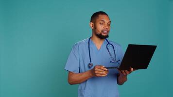 Practitioner in videocall meeting using laptop, greeting people. Healthcare expert in online telemedicine call with patients on notebook, isolated over studio background, camera B photo