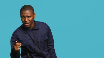 Bored security guard preventing criminal activity, patrolling around premises to deter criminals. Portrait of weary bodyguard walking around, lacking activity, studio background, camera A photo