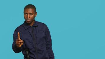 Security guard doing no gesturing with finger, prohibiting public access in restricted area. Portrait of stern bodyguard barring people from entering place, studio background, camera A photo