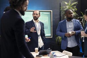Team members from a business corporation discussing details and progress in a new project during a corporate meeting. Firm employees are getting informed about marketing developments. photo