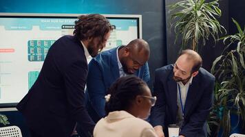 Business associates reviewing latest financial plans on documents, organizing a briefing meeting for sharing project updates and timelines to ensure progress. Coworkers making decisions. Camera A. photo