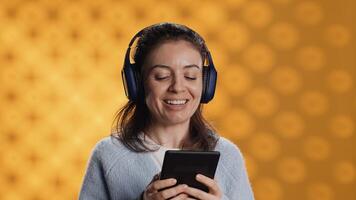 Voice actor smiling while reading ebook, portraying proud and sassy character, studio background. Woman reenacting digital novel, interpreting cheerful protagonist, reading text from tablet, camera A photo