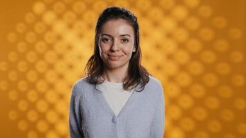 Cheerful woman happily doing salutation hand gesture, feeling optimistic. Portrait of joyous caucasian person raising arm to greet someone, gesturing, isolated over studio background, camera B photo