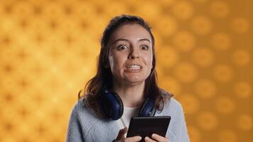 Voice actor reading ebook in entertaining manner in front of audience, portraying character, studio background. Woman reenacting digital novel for spectators, reading from tablet screen, camera A photo