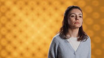 Portrait of upbeat optimistic woman posing, feeling happy and relaxed, isolated over yellow studio background. Close up shot of lively radiant caucasian lady standing, camera A photo