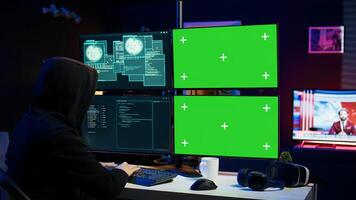 Cybercriminal using isolated screen PC in apartment hideout getting hacking attacks rejected by security. Hacker using chroma key computer monitor seeing access denied error message, camera B photo