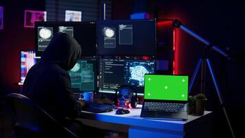 Hacker using isolated screen laptop and AI technology to deploy malware on unsecured devices. Scammer stealing sensitive data from unaware users using mockup notebook, camera B photo
