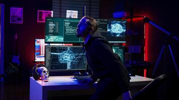 Hacker in hideout interrupted by police sirens from writing malware code on computer, running to escape before getting caught. Criminal den found by anti hacking law enforcement, camera B photo