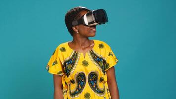 Young happy woman working with a virtual reality headset in studio, using the innovative 3d simulation experience with modern equipment. VR glasses on girl in traditional ethnic clothes. Camera A. photo